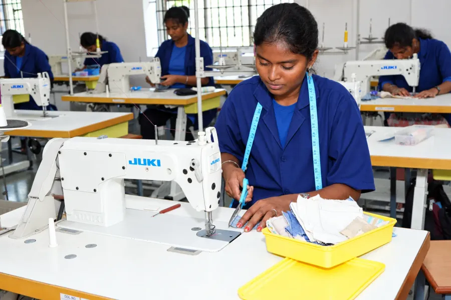Machinists at work on industrial sewing machines in a garment workshop